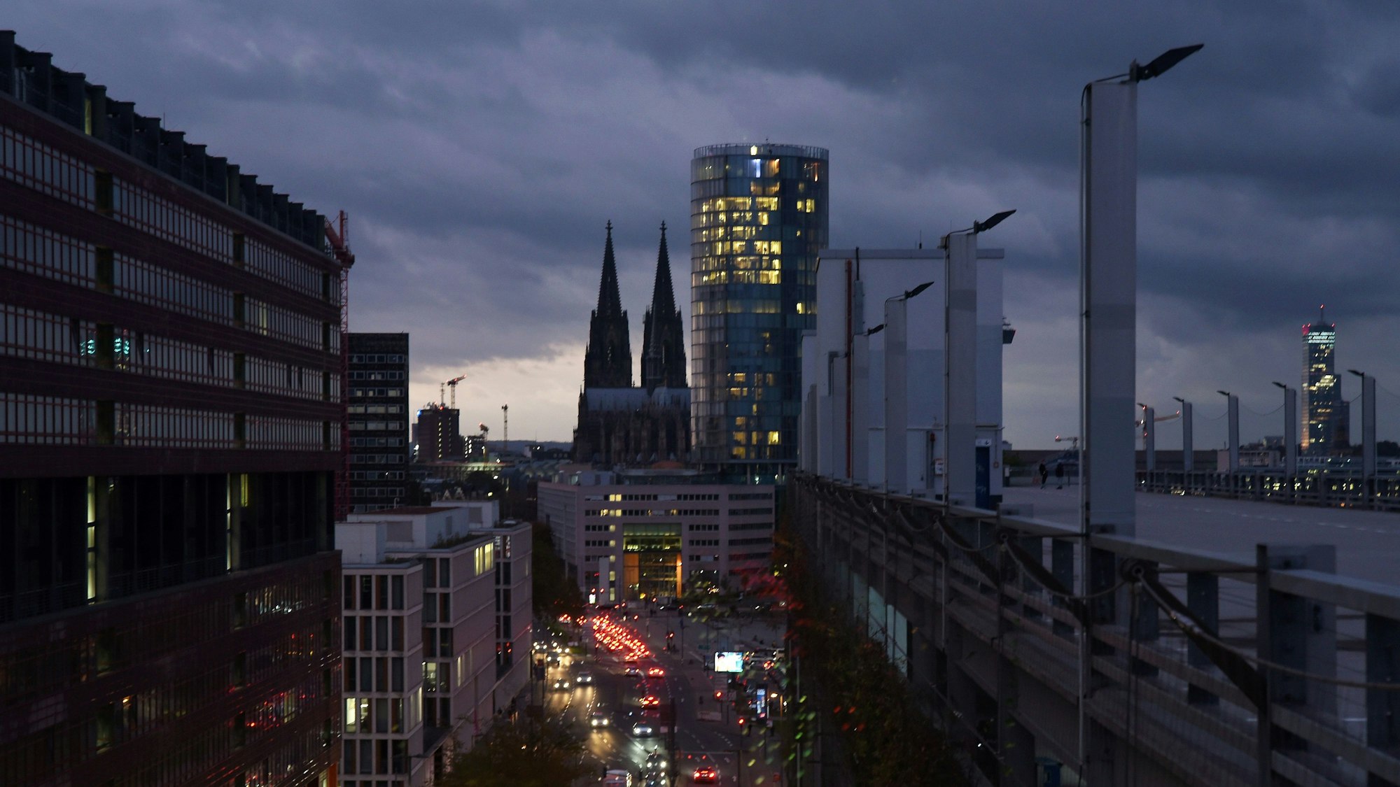 Blick auf den Kölner Dom mit bewölktem herbstlichem Abendhimmel als Hintergrund vom Deutzer Stadthaus aus fotografiert. Rechts im Bild: das Hochhaus Köln-Triangel, in dem die Metropolregion Rheinland ihren Sitz hat.