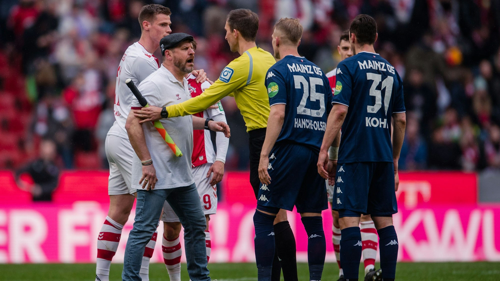Kölns Trainer Steffen Baumgart (l) liefert sich nach der Partie ein Wortgefecht mit den Mainzer Spielern Andreas Hanche-Olsen und Dominik Kohr (r).