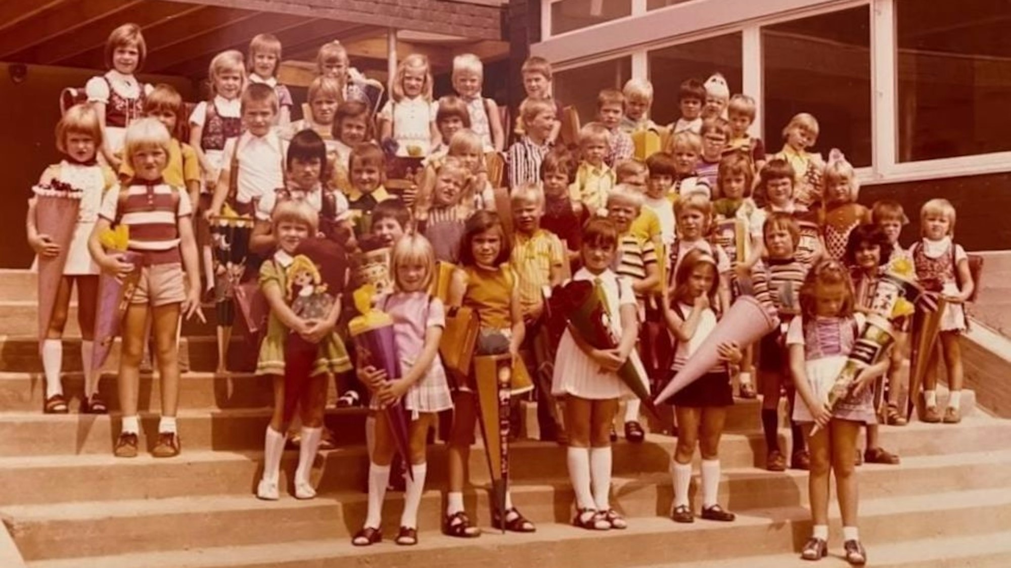 Auf einem alten Foto aus dem Jahr 1973 ist eine Schulklasse bei der Einschulung zu sehen. Die Kinder halten Schultüten in den Händen.