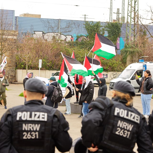 Polizisten beobachten die Kundgebung in Köln-Mülheim.