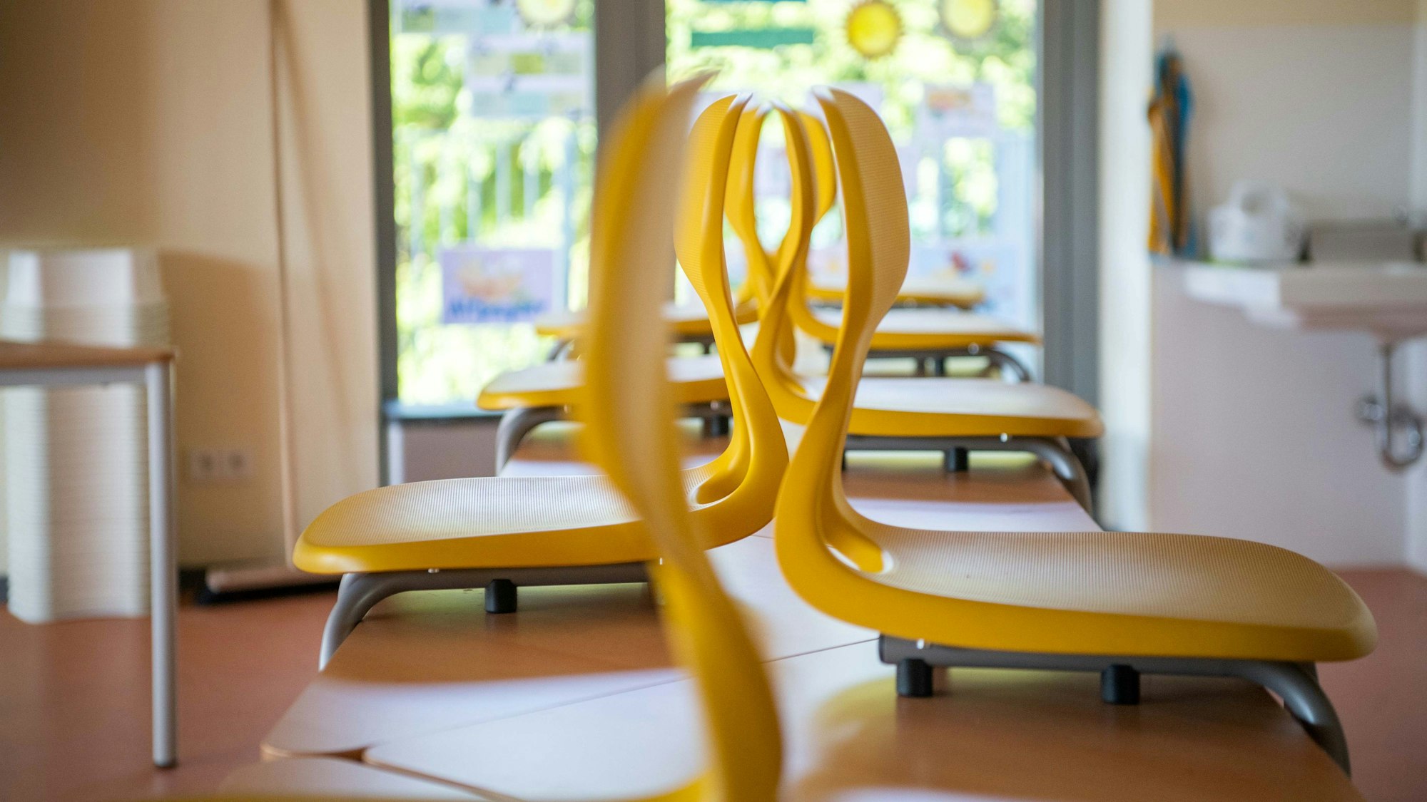 Die Stühle sind einer Schule auf die Tische gestellt.