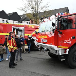 Es ist ein Fahrzeug der Waldbröler Feuerwehr zu sehen. Neben diesem stehen mehrere Menschen.&nbsp;