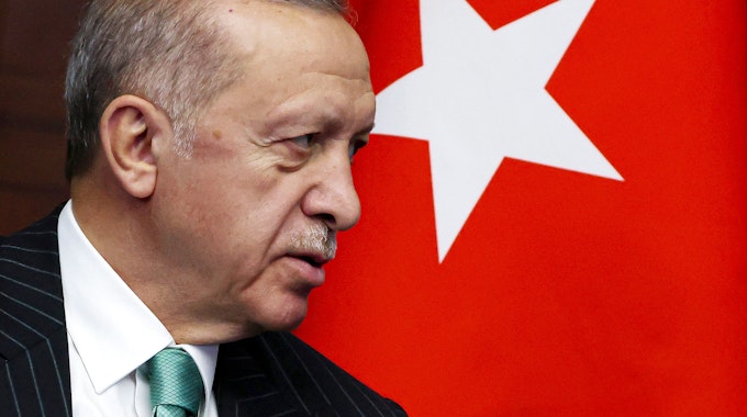 Recep Tayyip Erdogan, Präsident der Türkei, steht neben einer türkischen Flagge