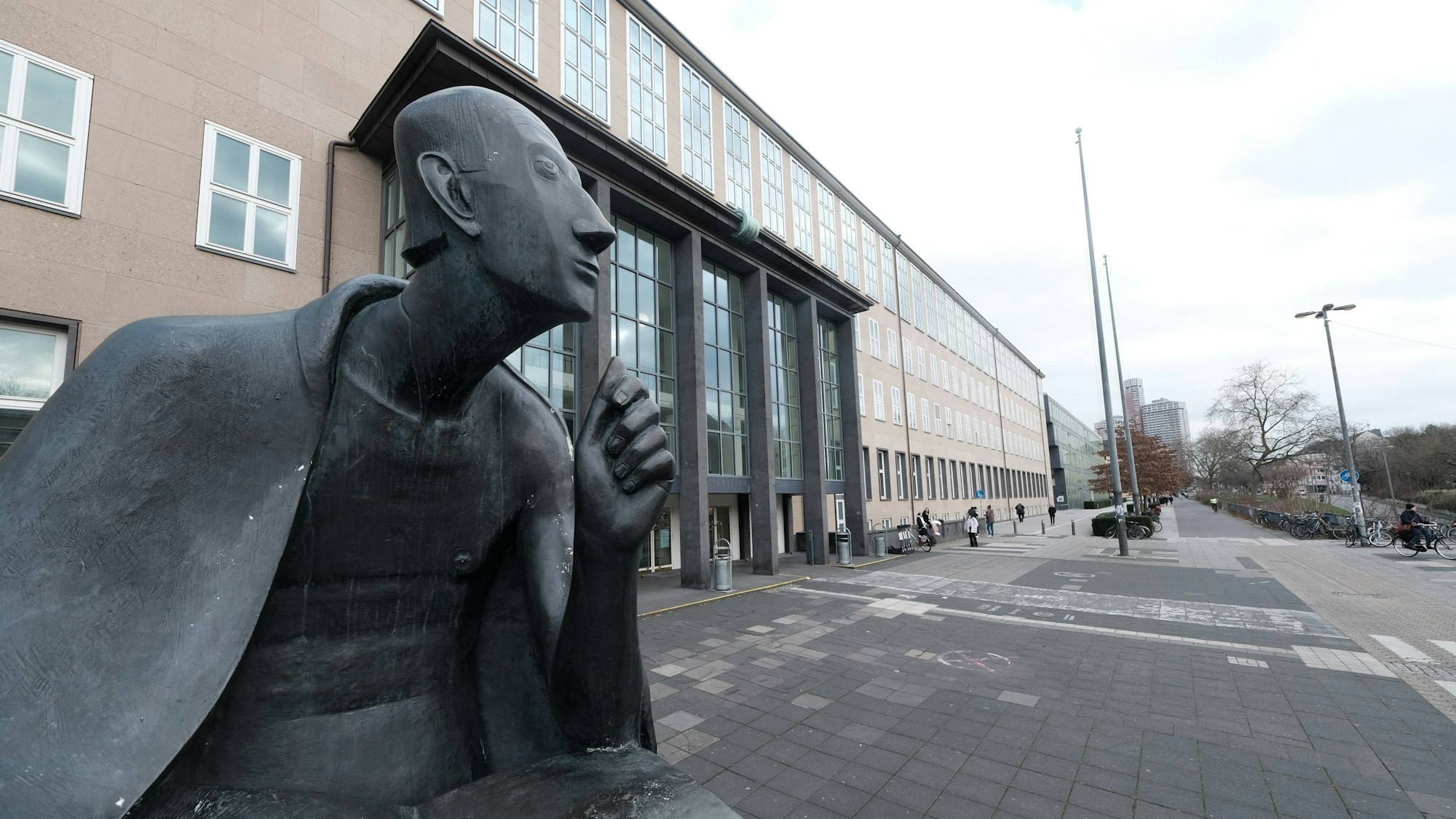 Das Bild zeigt die Bronzestatue von Albertus Magnus vor der Universität zu Köln.