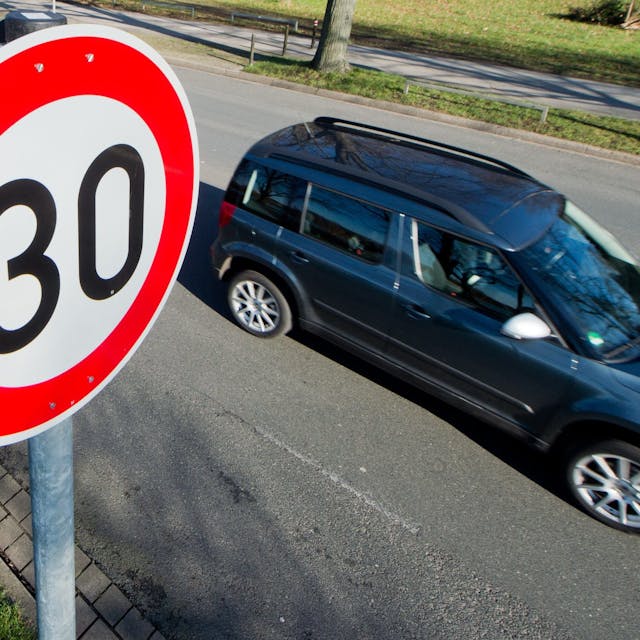 Ein Auto fährt an einem Verkehrsschild für eine Geschwindigkeitsbegrenzung von 30 Stundenkilometer vorbei.
