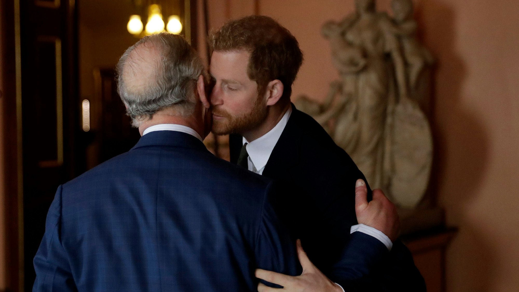 König Charles III. und Prinz Harry umarmen sich.