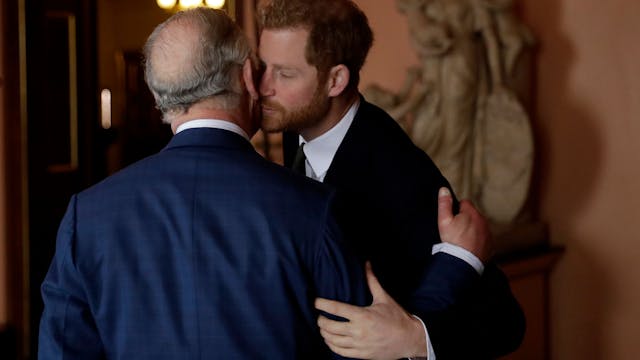 König Charles III. und sein Sohn, Prinz Harry, küssen sich auf die Wange.
