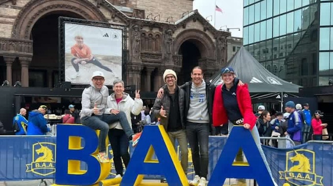 Jörg Löhr und Begleiter vor dem Schild des Boston Marathon