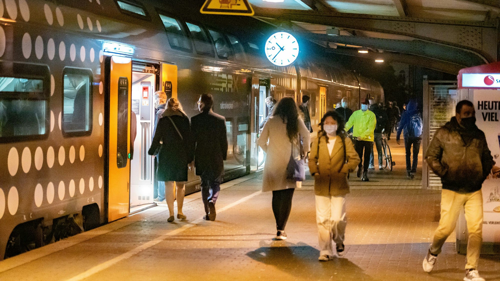 Menschen steigen am Kölner Bahnhof Süd aus einem Zug aus, andere steigen ein.
