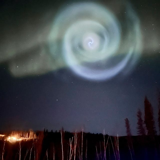 Eine hellblaue Spirale, die wie eine Galaxie aussieht, ist am Samstag zwischen Nordlichtern für ein paar Minuten am Himmel in Alaska zu sehen gewesen.&nbsp;