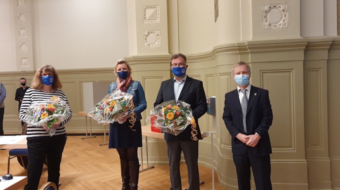 Zwei Frauen und zwei Männer – wegen Corona alle mit blauem Mundnasenschutz – stehen nebeneinander im Kurssaal. Die drei gerade gewählten Vize-Bürgermeister halten Blumensträuße in den Händen.
