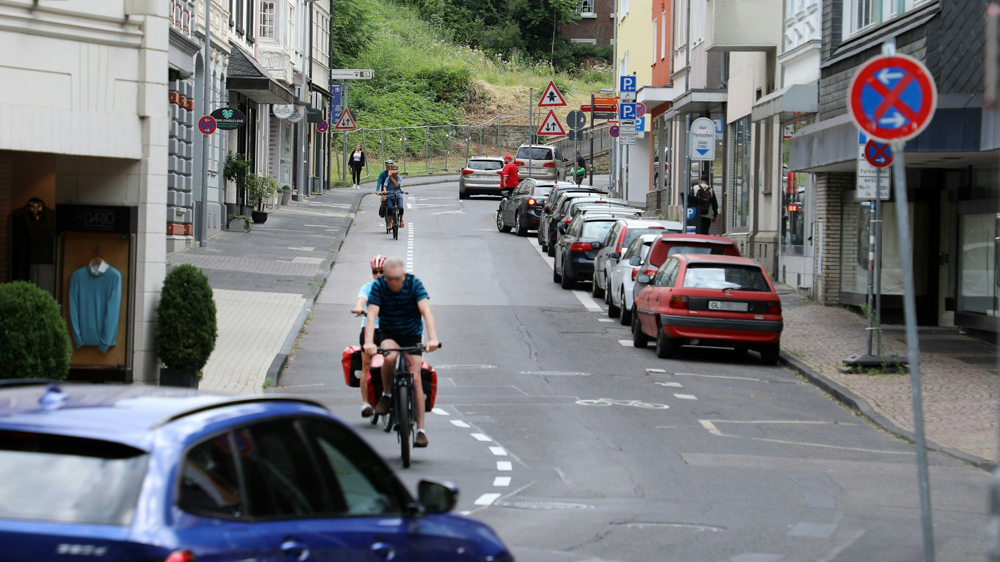 Die Laurentiusstraße in Bergisch Gladbach mit Fahrradfahrenden, Autos und Häusern.