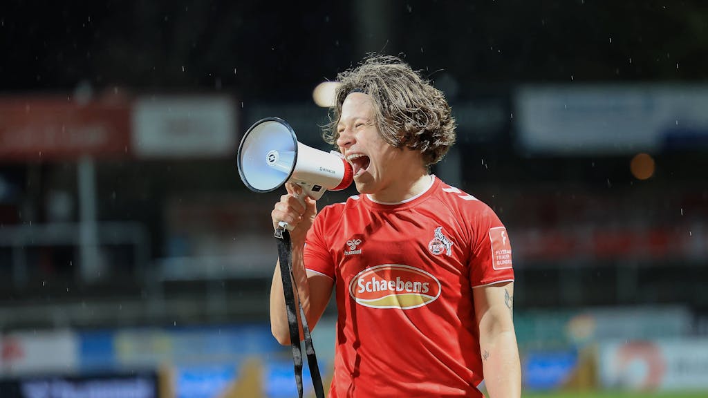 Ally Gudorf feiert mit Megafon den Sieg des 1. FC Köln gegen Duisburg.