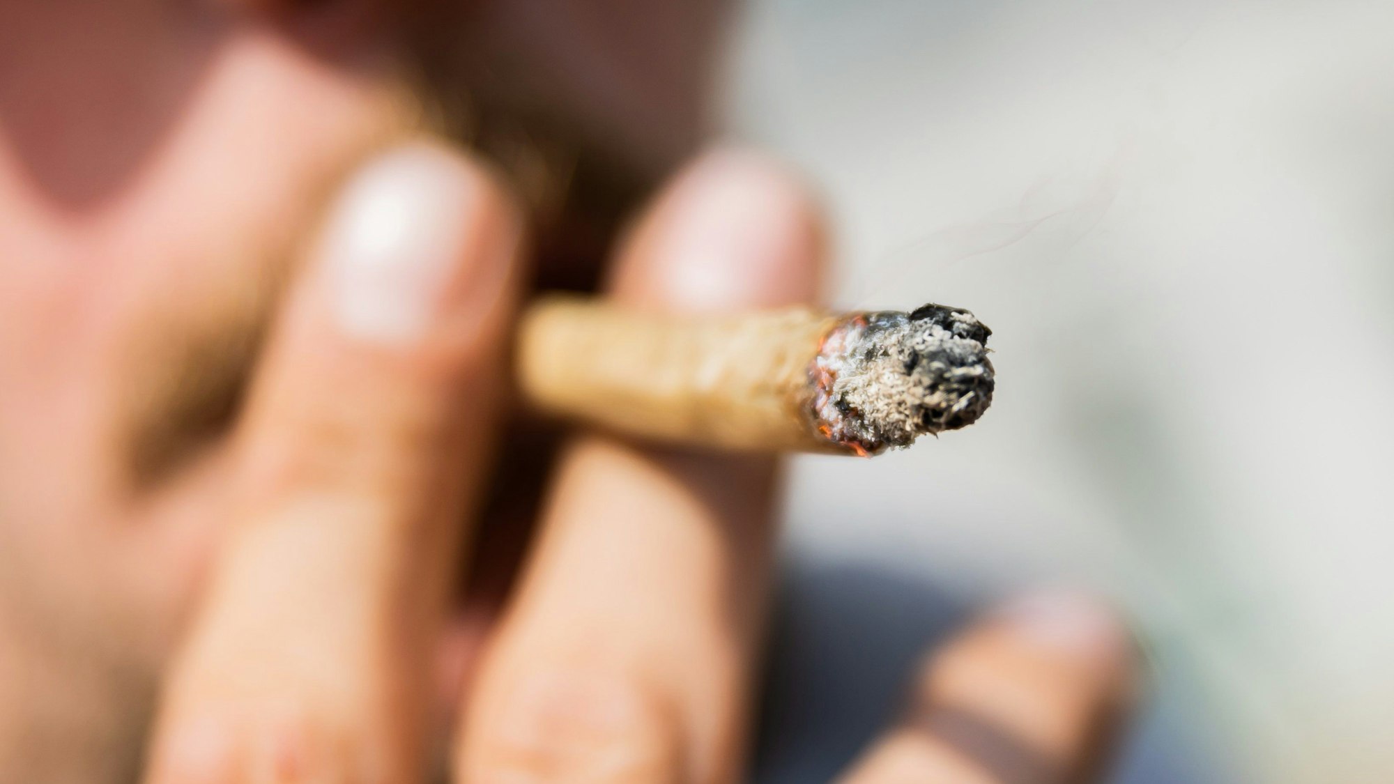Ein Mann raucht bei einer Demonstration für eine zügige Legalisierung von Cannabis einen Joint mit Medizinalcannabis.