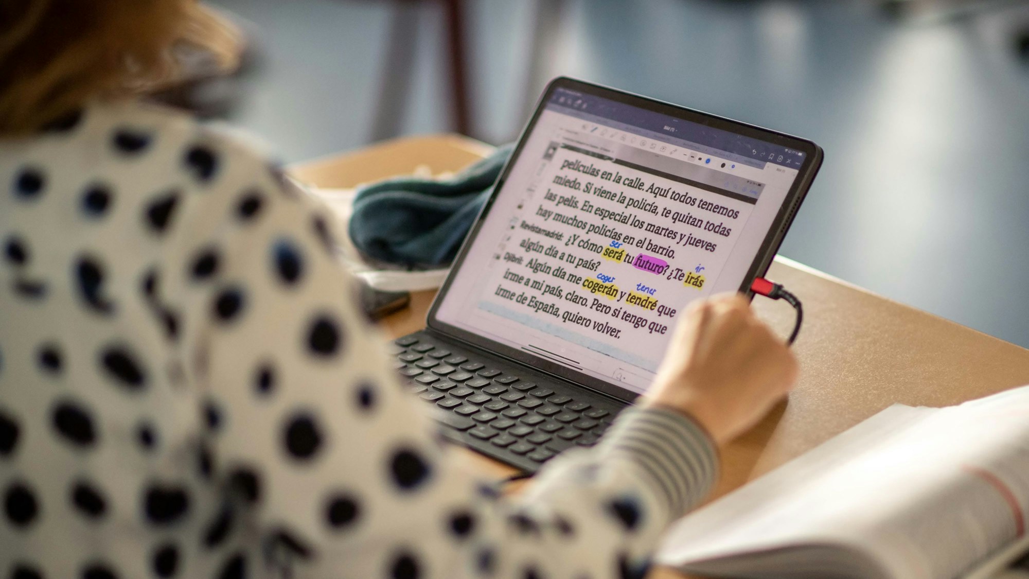 Eine Schülerin studiert einen spanischen Text auf ihrem Tablet.