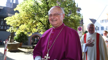 Der ehemalige Freiburger Erzbischof Robert Zollitsch steht vor einem Baum.