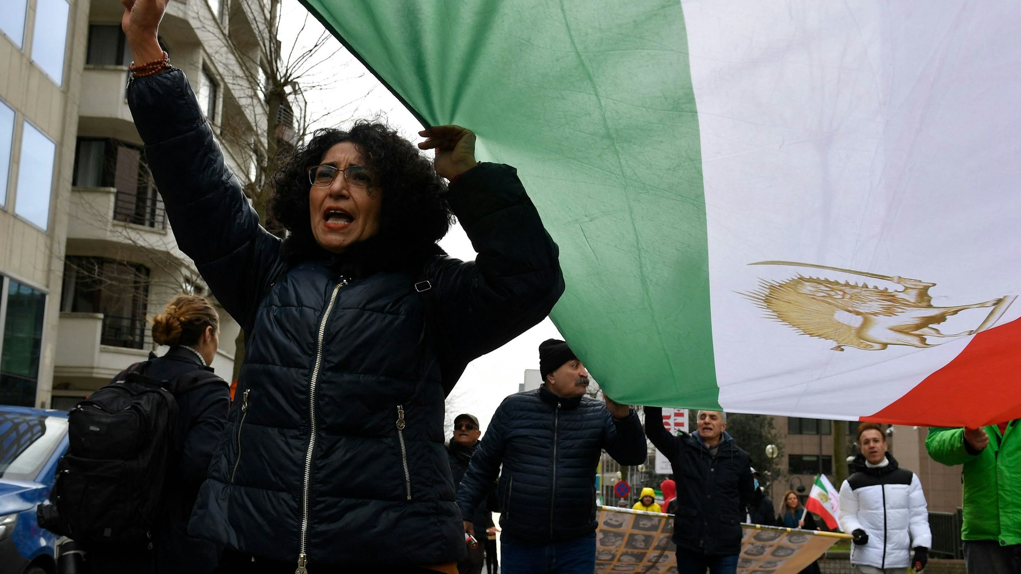 Demonstrantin hält eine iranische Flagge