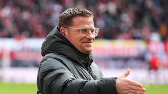 Max Eberl, Geschäftsführer Sport von RB Leipzig, streckt am 11. März 2023 seine rechten Hand zum Handschlag nach vorne und lächelt im Rahmen des Bundesliga-Spiels gegen Borussia Mönchengladbach.