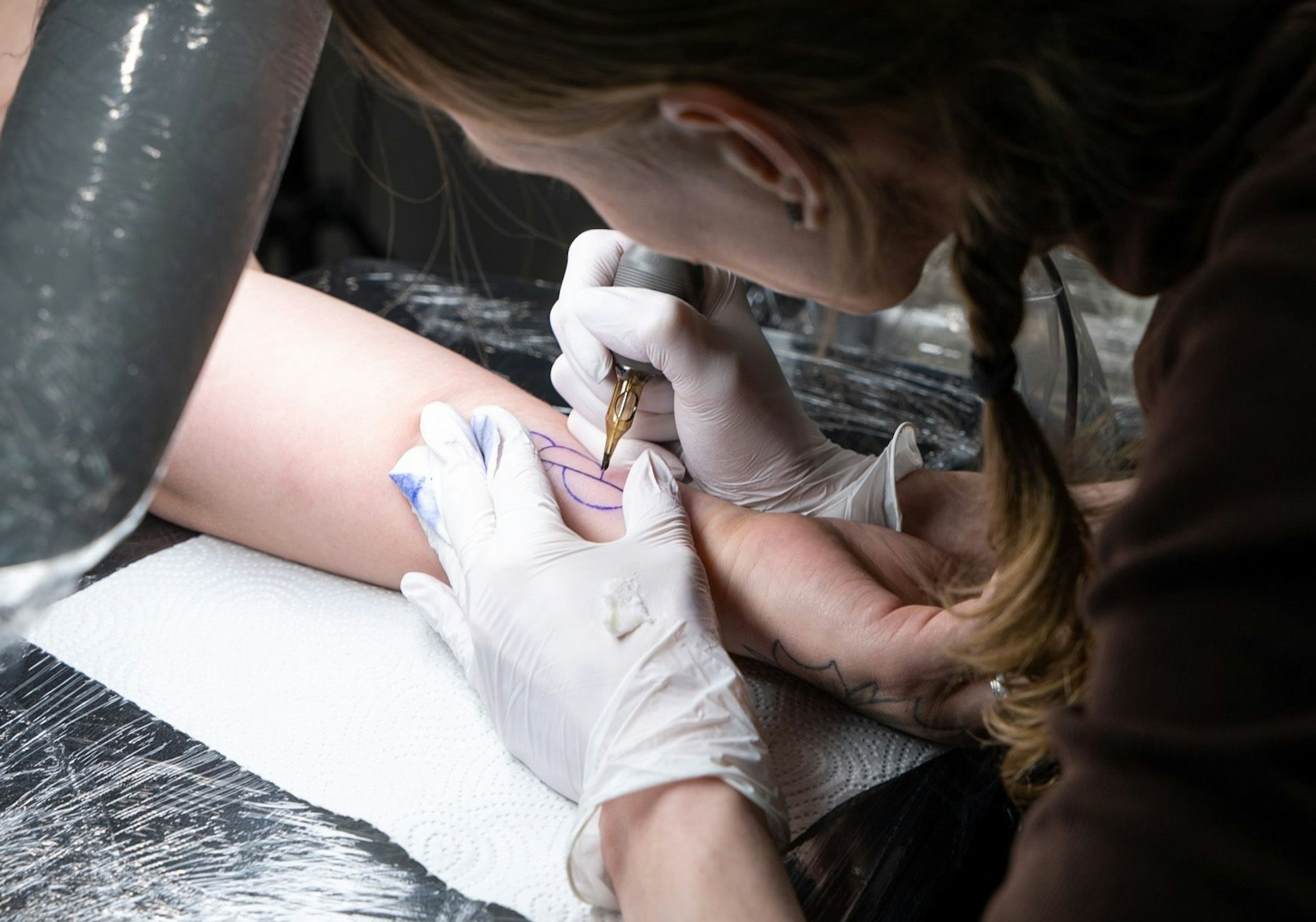 Inna Fisher sticht das Organspende-Tattoo auf Antonia Hartrampfs Handgelenk.