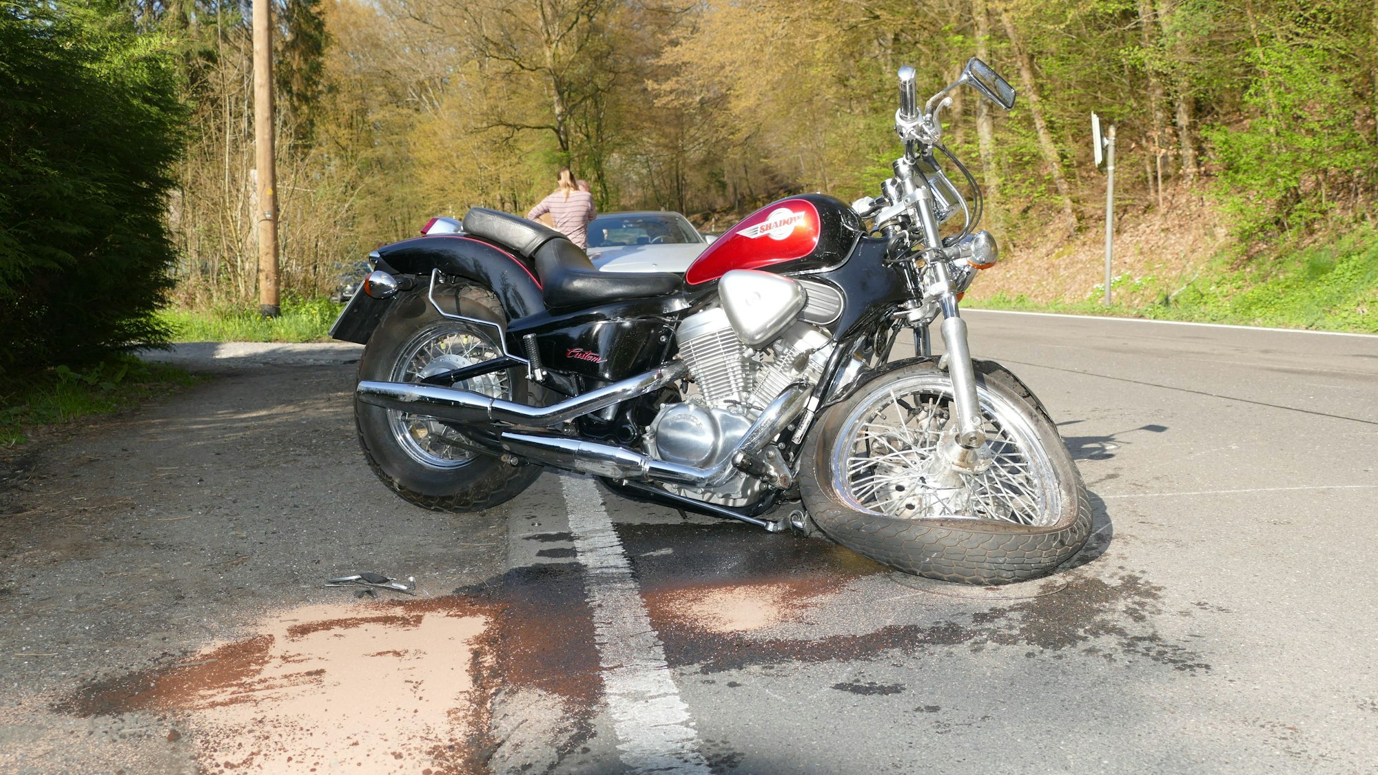 Ein Motorrad mit demoliertem Vorderrad steht auf einer Straße.