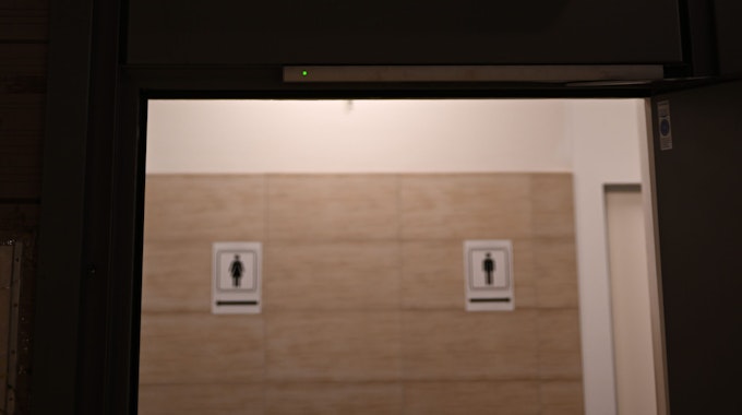 Ein beleuchtetes Hinweisschild mit Piktogrammen ist in der B-Ebene der Konstablerwache vor einem öffentlichen WC für Frauen und Männer angebracht.