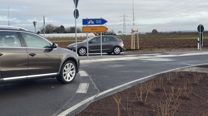 Ein Auto biegt an einem Kreisel ab, Straßenschilder zeigen die Richtungen Bonn und zur Autobahn 565 sn.&nbsp;