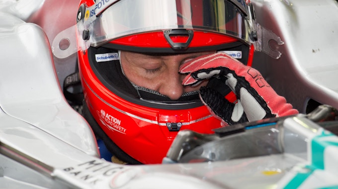 Formel-1-Weltmeister Michael Schumacher sitzt in einem Formel-1-Wagen des deutschen Rennstalls Mercedes. Er trägt seinen markanten roten Helm.