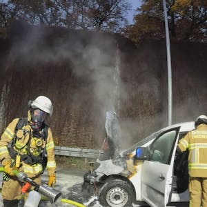 Aufnahme einer Bodycam. Zwei Feuerwehrmänner im Einsatz löschen einen weißen PKW.