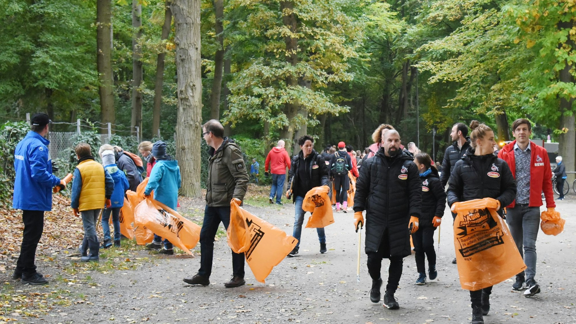 Menschen sammeln in Köln Müll auf.