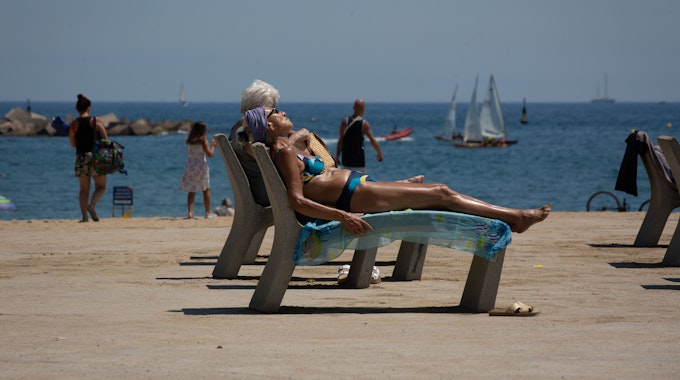 Mehrere Personen sonnen sich am Strand von Barceloneta. Die Temperaturen in Spanien klettern angesichts der aktuellen Hitzewelle auf Spitzenwerte. +++ dpa-Bildfunk +++
