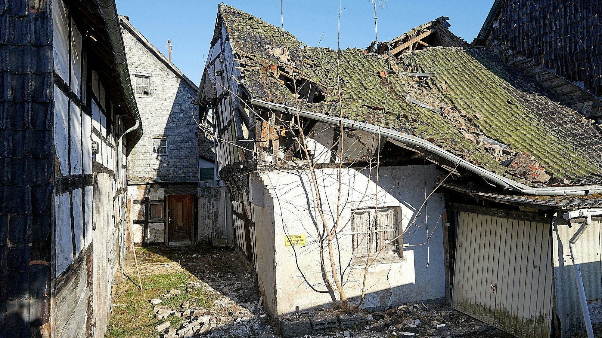 Das angeblich älteste Fachwerkhaus Hellenthal mit eingedelltem, teils eingestürztem Dach und verwahrloster Fassade.