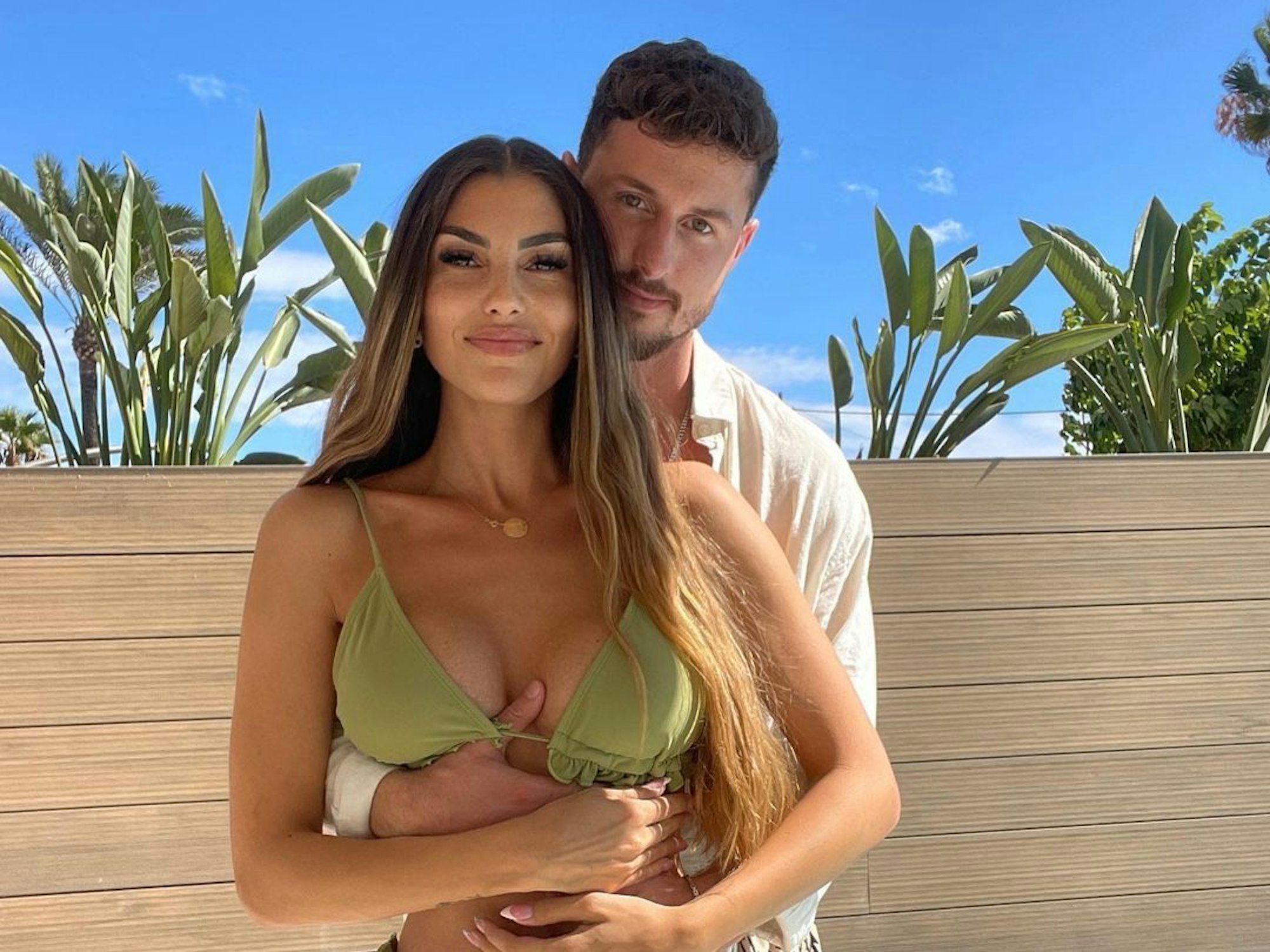 Yeliz Koc und Jannik Kontalis, Instagramfoto von März 2023, blicken in die Kamera und umarmen sich dabei. Yeliz trägt einen grünen Bikini und Jannik ein beiges Hemd.
