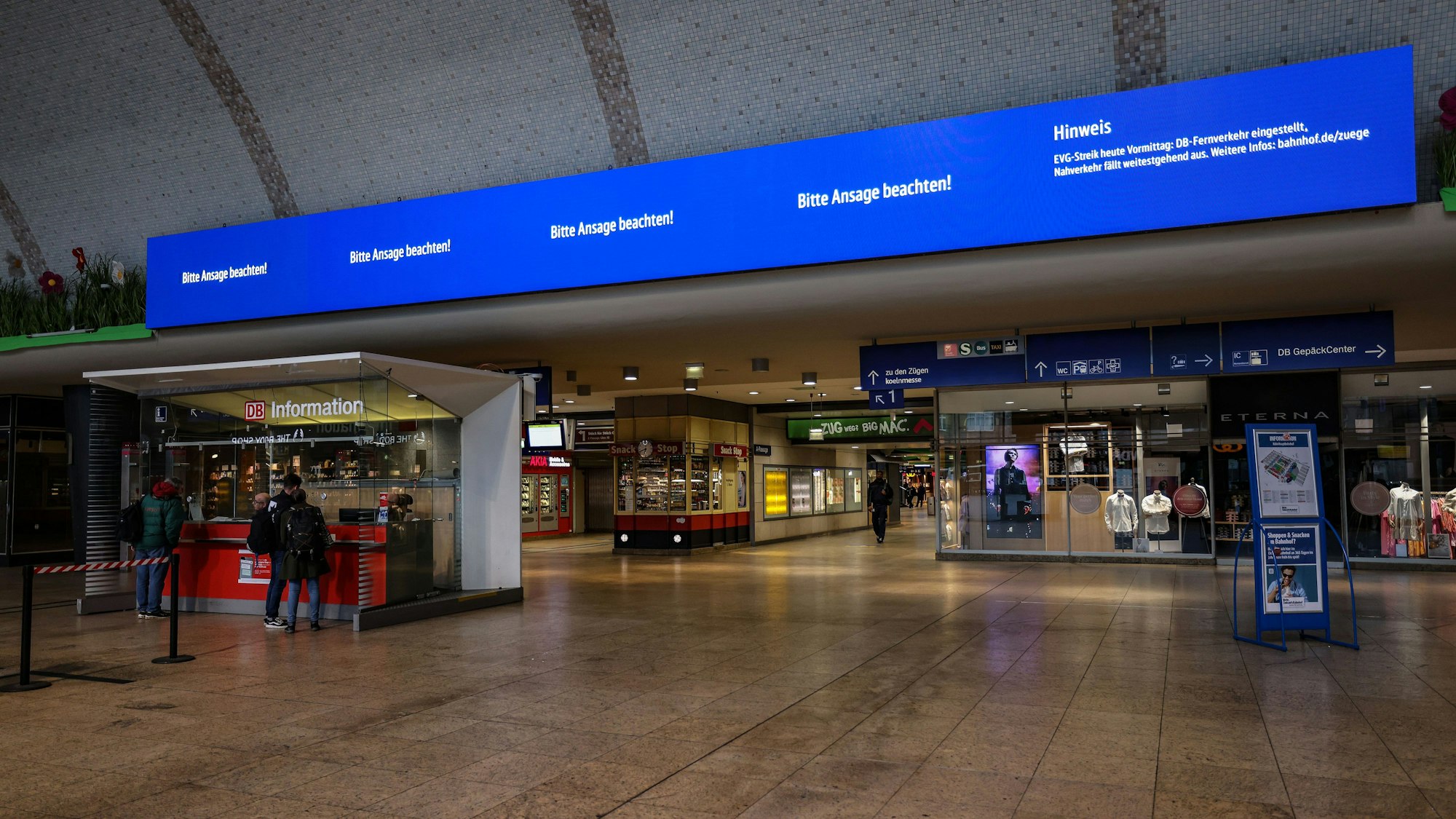Auf einer Anzeigetafel im Hauptbahnhof Köln steht ‚Bitte Ansage beachten‘ neben einem Hinweis auf die Folgen des Warnstreiks.