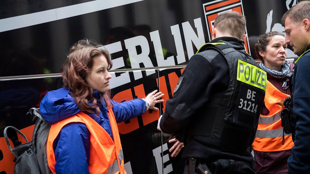 Zwei Klimaaktivistinnen haben sich an einem Reisebus vor dem Marriott Hotel am Potsdamer Platz in Berlin geklebt.