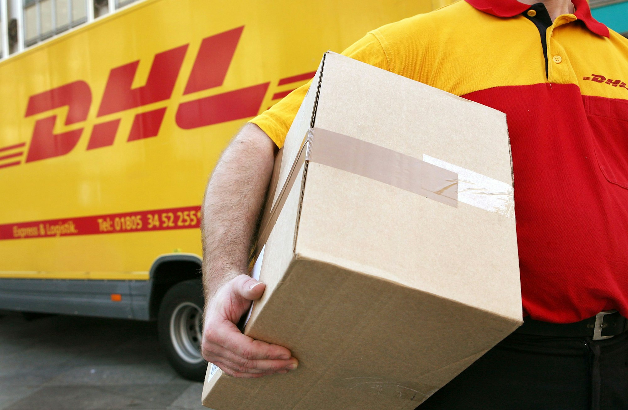 Ein Mitarbeiter des Paketdienstleisters DHL der Deutschen Post trägt ein Paket. Symbolfoto vom 12. November 2008.