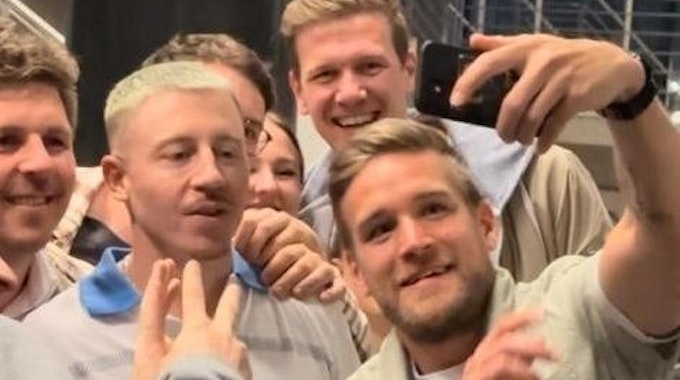 Einige Macklemore-Fans machen Selfies mit dem Star im Treppenhaus.