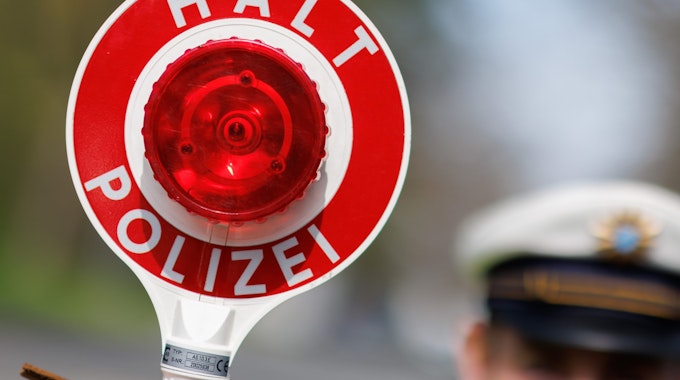 21.04.2023, Bayern, Nürnberg: Ein Polizist zieht ein Fahrzeug mit seiner Kelle aus dem Verkehr.&nbsp;