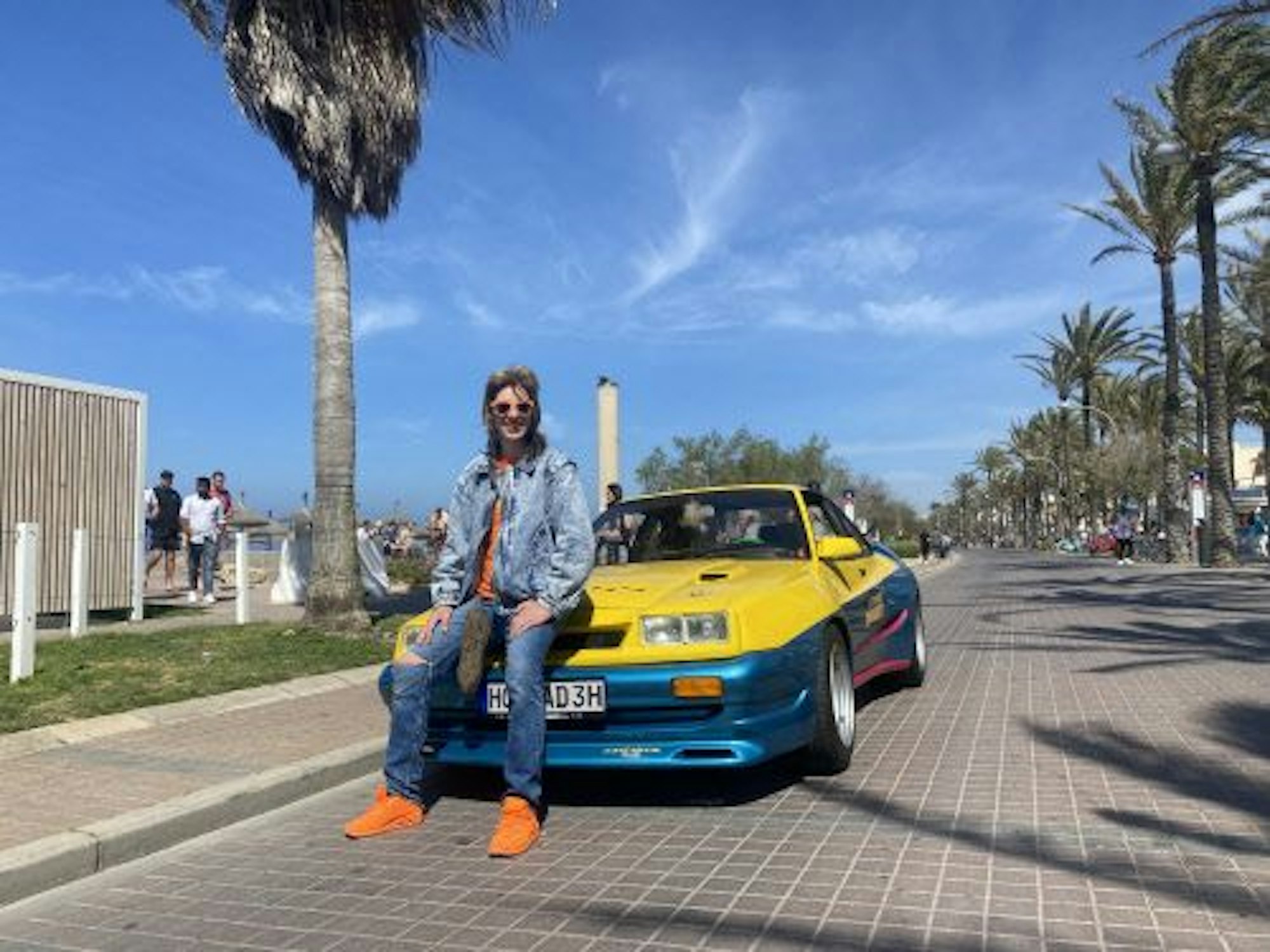 Manni Manta sitzt auf dem Opel Manta am Ballermann auf Mallorca.