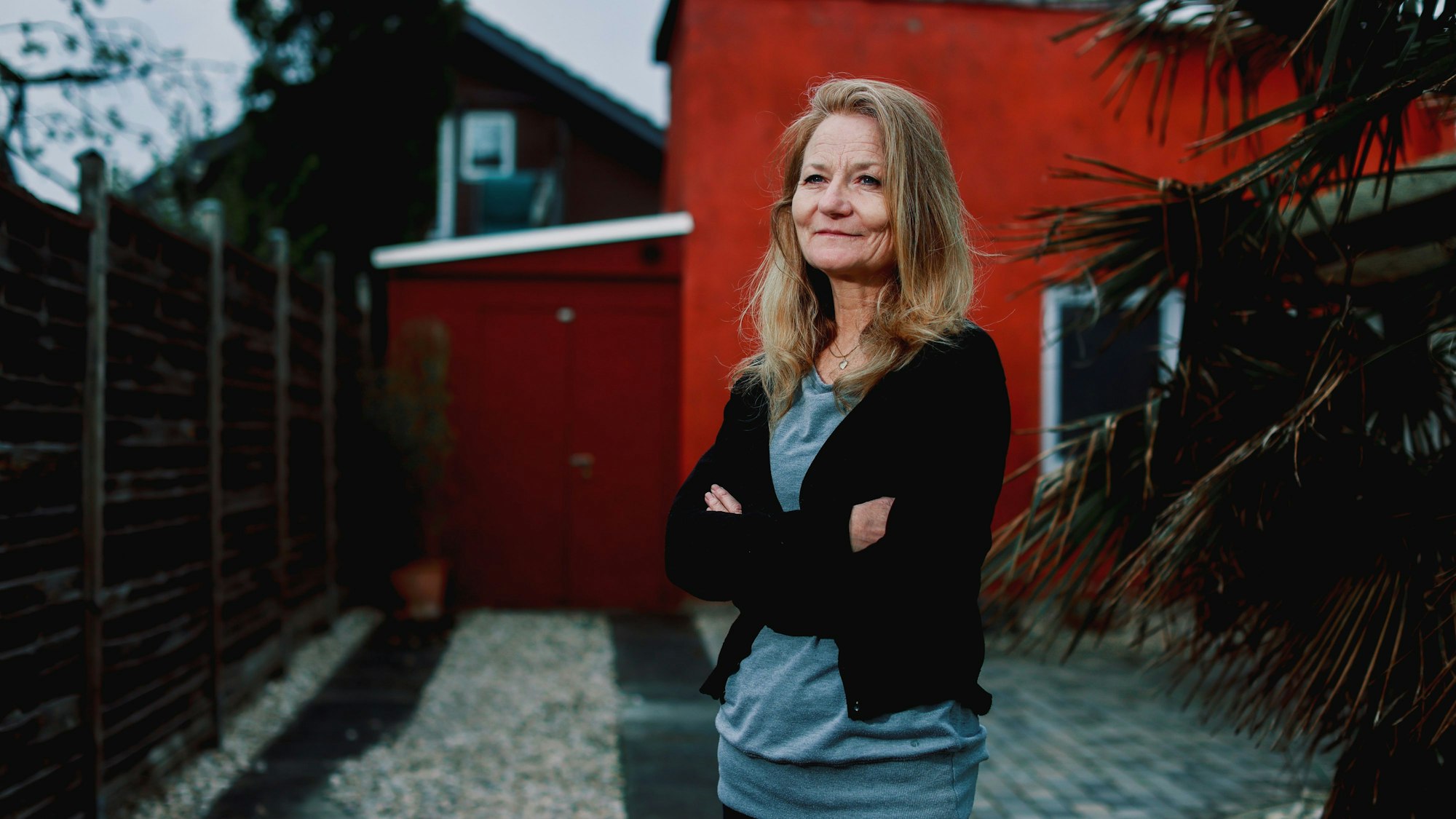 Bettina Linden-Paquignon steht vor einem roten Haus in Bonn.