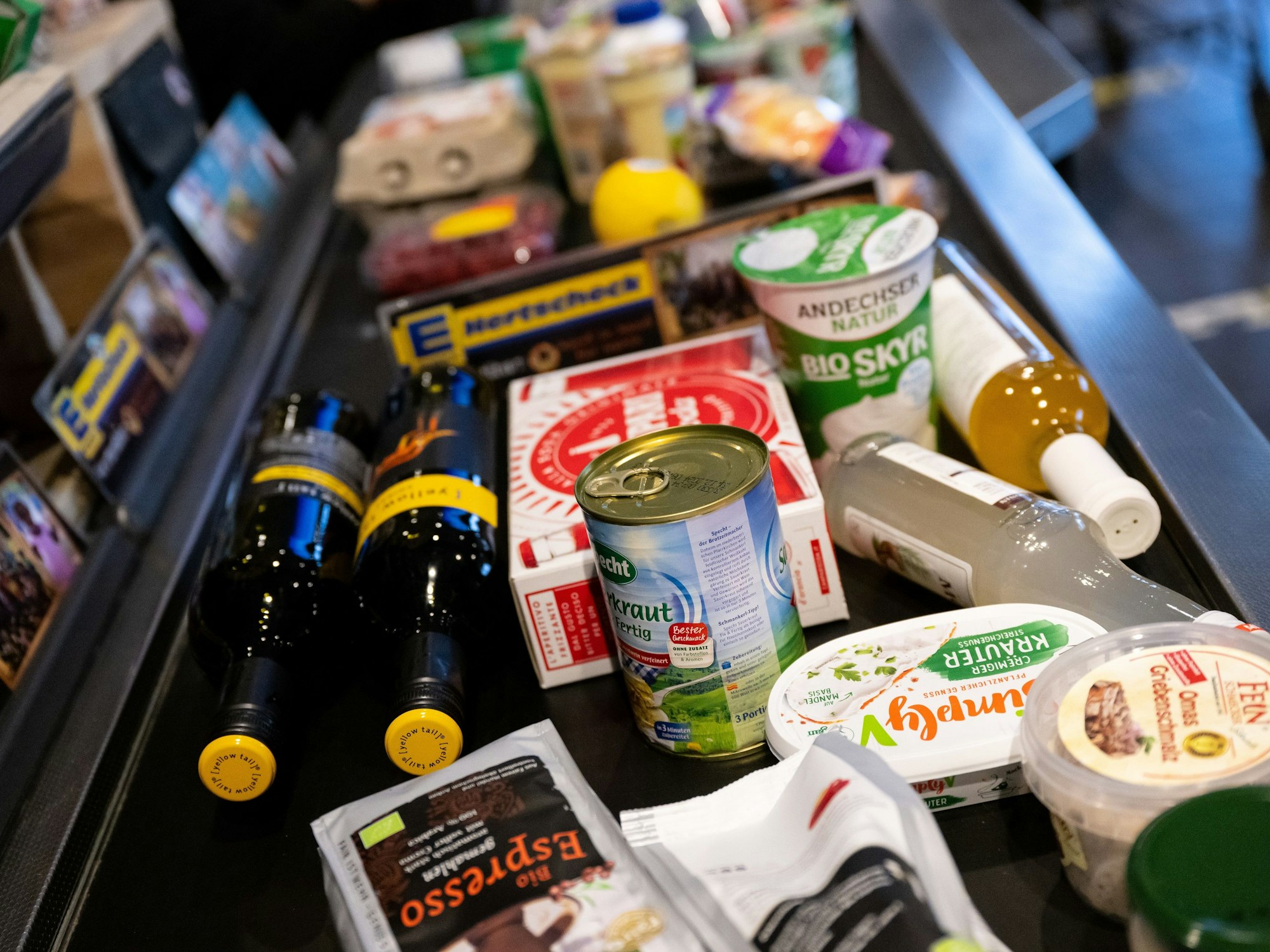 Lebensmittel liegen im Januar 2023 in einem Supermarkt an der Kasse auf dem Band. Aus Expertensicht gibt es Anzeichen für überhöhte Preise bei Lebensmitteln in Deutschland.