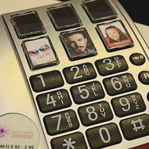 Ein Seniorentelefon mit großen Tasten und Bildern für wichtige Kontakte.
