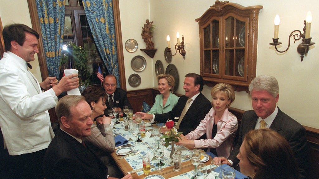 Während ein Kellner Wein ausschenkt, unterhalten sich (von links im Uhrzeigersinn) Jean Chretien, Cherie Blair, Jacques Chirac, Hillary Clinton, Gerhard Schröder, Doris Schröder-Köpf, Bill Clinton und Aline Chretien in Köln