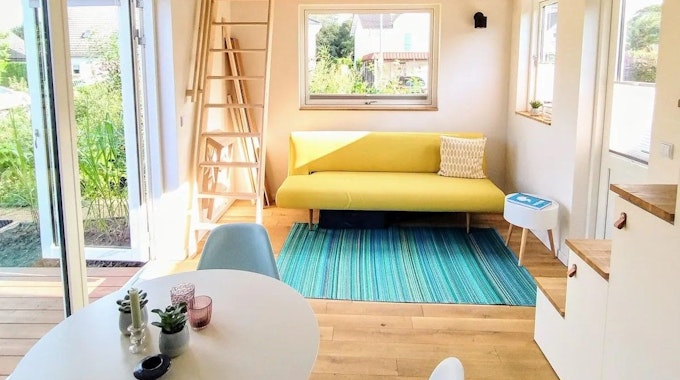 Blick auf eine Couch in einem Tiny House im Siebengebirge, das über Airbnb angeboten wird.