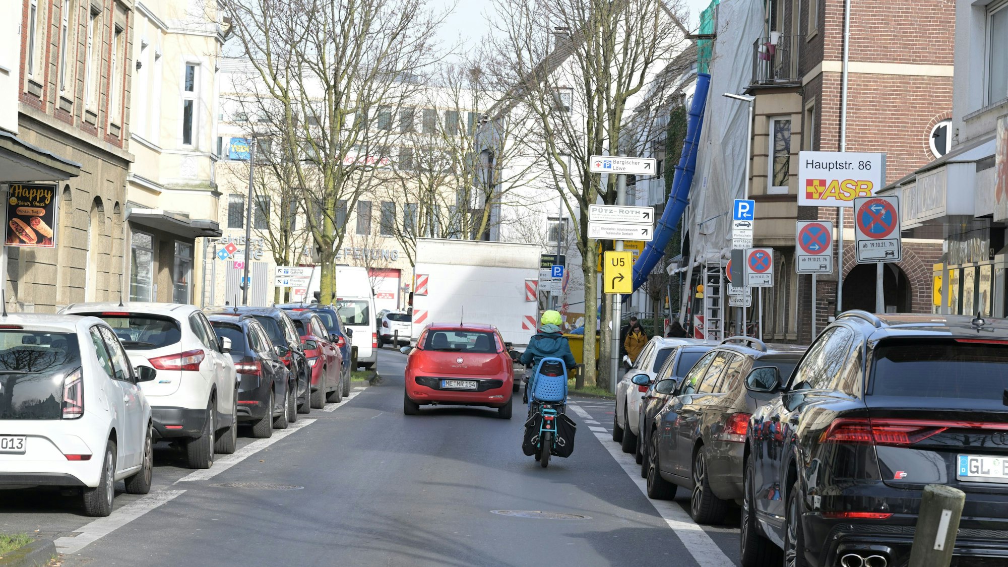 Ein Auto und ein Motorrad fahren auf der unteren Hauptstraße in Bergisch Gladbach.