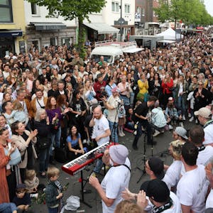 Ein Chor singt auf der voll gefüllten Venloer Straße.