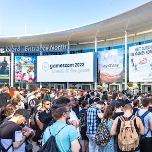 Mehrere Besucher der Gamescom stehen am Haupteingang der Messe.