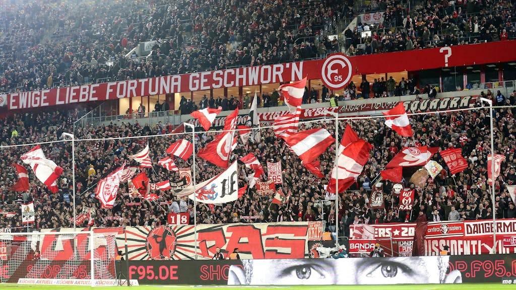 Fans von Fortuna Düsseldorf schwenken ihre Fahnen vor Spielbeginn.
