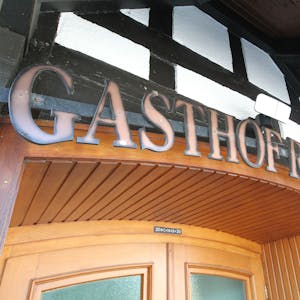 Über einer Holztür, vor dem Hachwerk, prangt der Name „Gasthof Röttgen“.