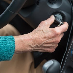 Eine Rentnerin startet mit dem Zündschlüssel ihr Auto.