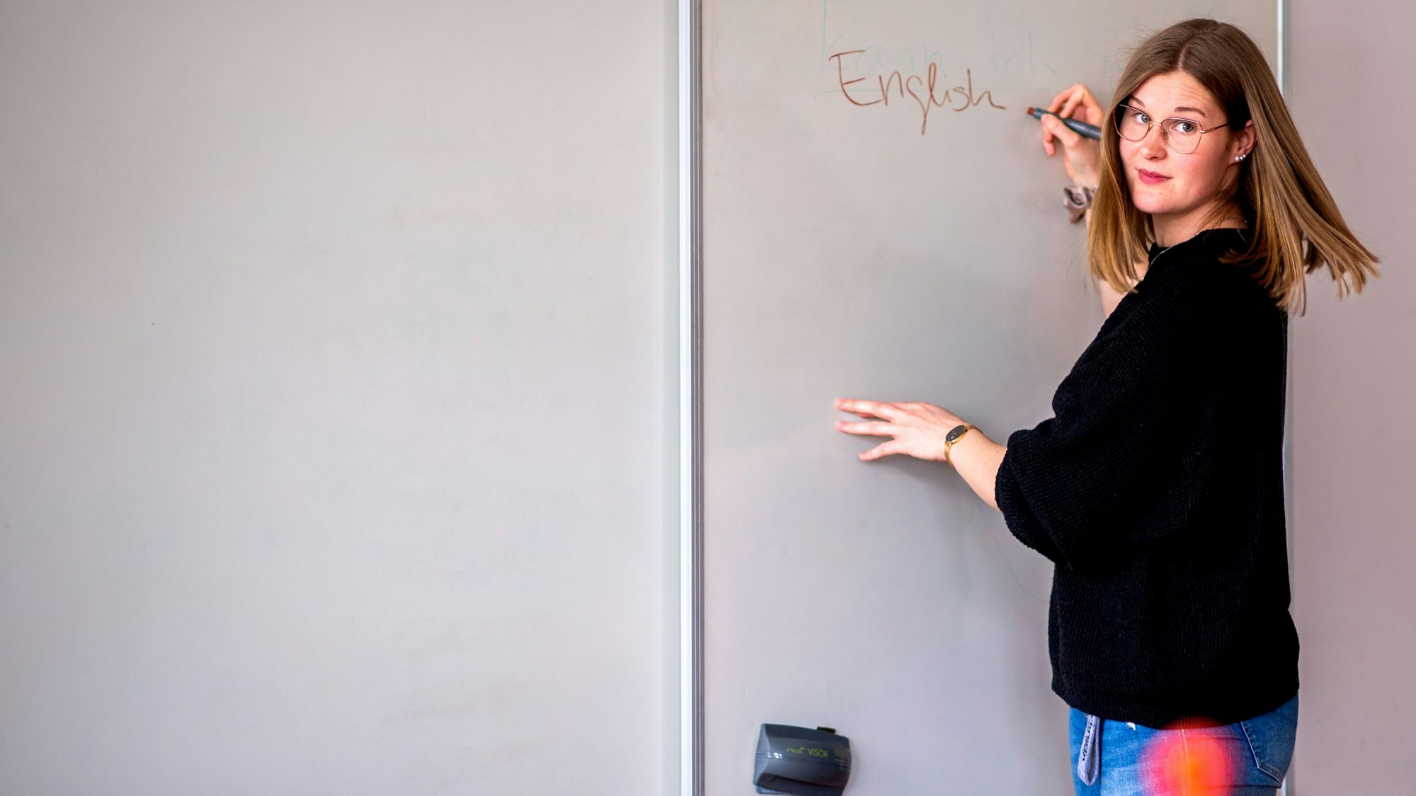Die Euskirchener Lehrerin Alina Heuschkel steht an einer Tafel und schreibt das Wort English.